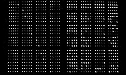 An image of a black screen with many dots, representing a punch-card computer system